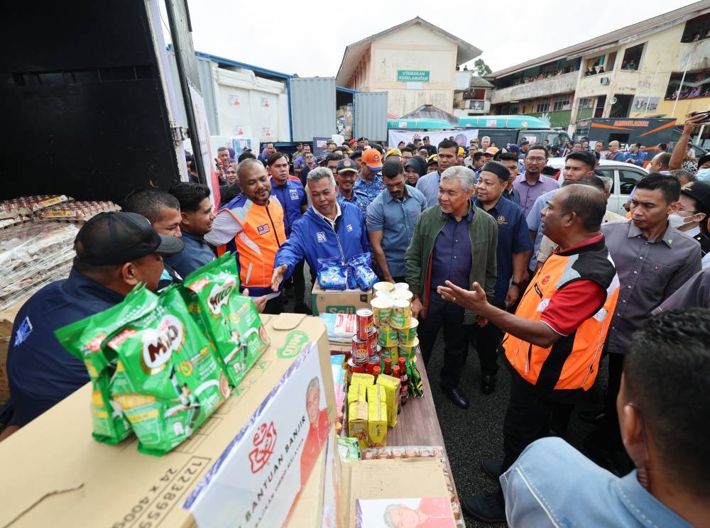 Datuk Seri Ahmad Zahid Hamidi checks on food supplies to be distributed to flood victims at a temporary flood relief centre in Chukai December 22, 2022. — Bernama pic