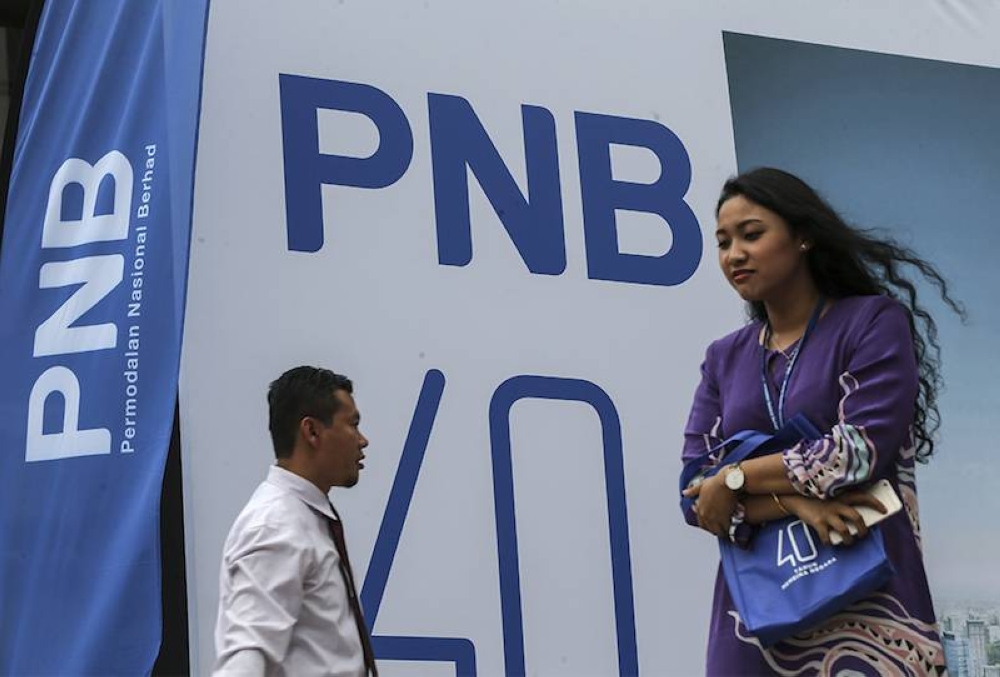 People walk past a Permodalan Nasional Bhd logo in Kuala Lumpur March 15, 2018. — Picture by Azneal Ishak