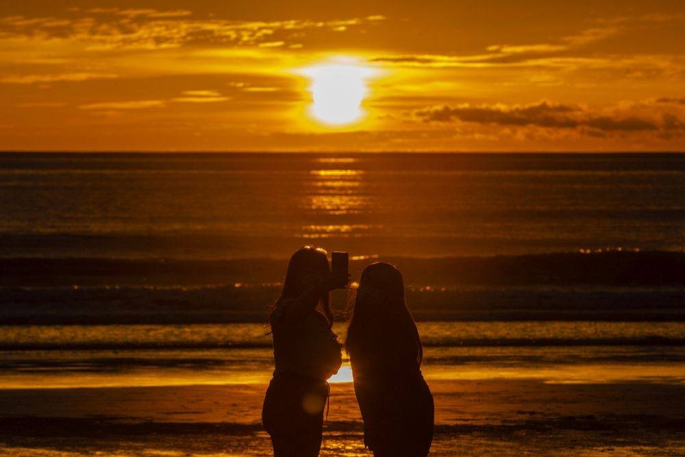 People take a picture of the setting sun on the Tanjung Aru beach in Kota Kinabalu September 30, 2020. — Picture by Firdaus Latif