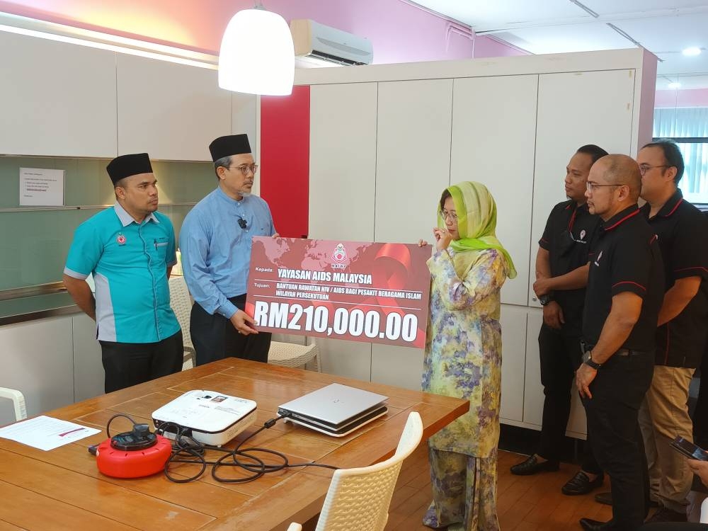 Dr Yusri Mohamad (second from left) presented zakat worth RM210,000 to MAF Chairman Prof Datuk Dr Adeeba (right). — Picture courtesy of Malaysian AIDS Foundation