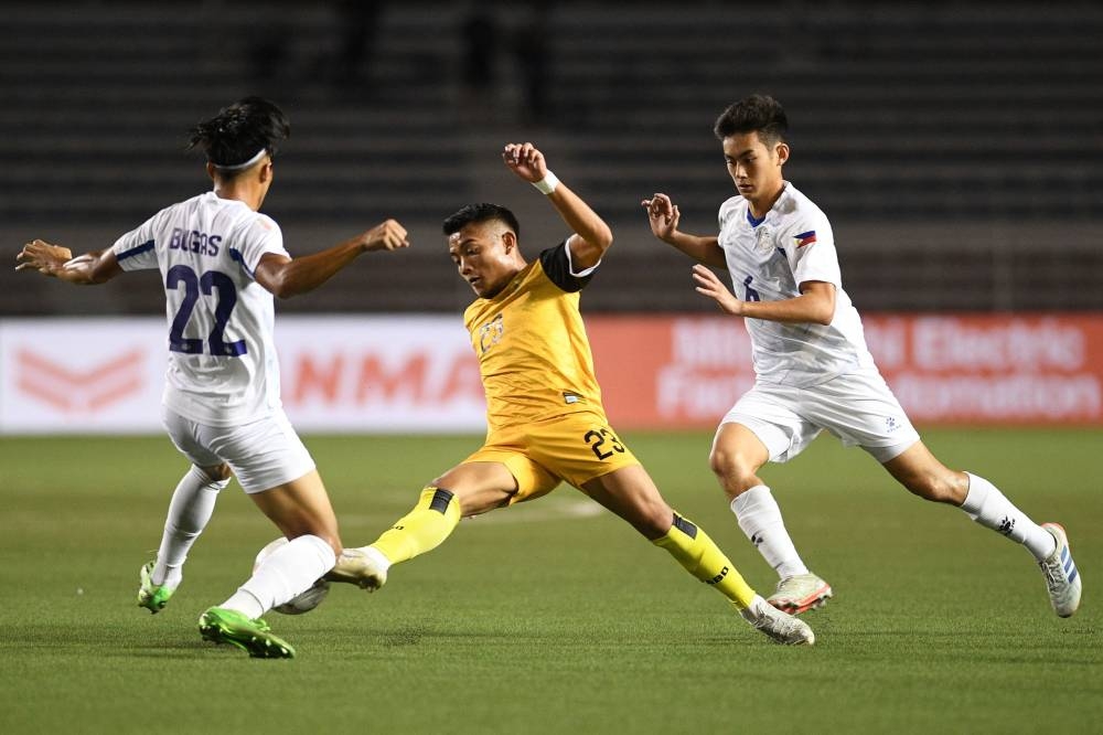Hakeme Yazik of Brunei (centre) fights for the ball with Pocholo Bugas (left) and Sandro Reyes of the Philippines during their AFF Mitsubishi electric Cup 2022 football match at Rizal memorial stadium in Manila, December 23, 2022. — AFP pic