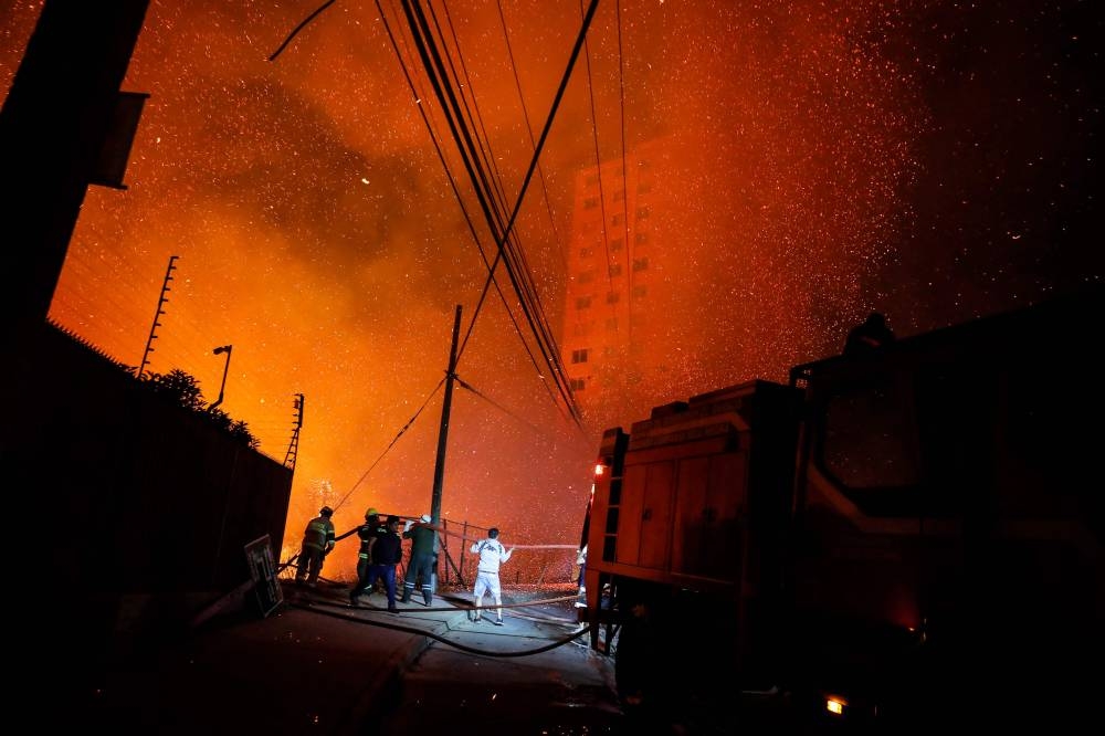 Firefighters work as a forest fire affects the hills of Vina del Mar, where hundreds of houses are located, in the Valparaiso Region, Chile, on December 23, 2022 — AFP pic