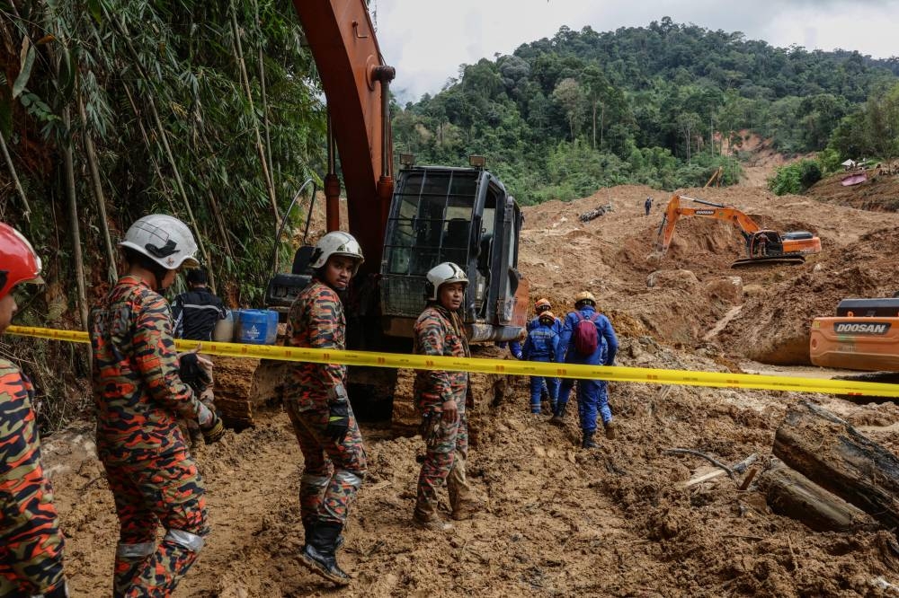 Members of the Malaysian Fire and Rescue team entering the site of the landslide tragedy at the Father's Organic Farm campsite, Gohtong Jaya, to search for buried victims, December 23, 2022. — Bernama pic