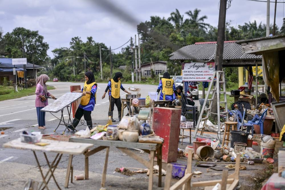 Volunteers work together to clean the houses of flood victims in Kampung Paya Besar, Hulu Terengganu, December 25, 2022. — Bernama pic