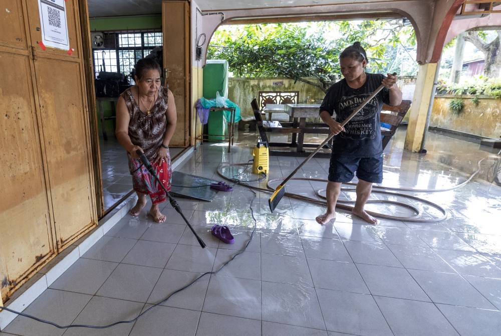 People clean their home as floodwaters recede in Kampung Jubakar Darat, Tumpat December 25, 2022. — Bernama pic