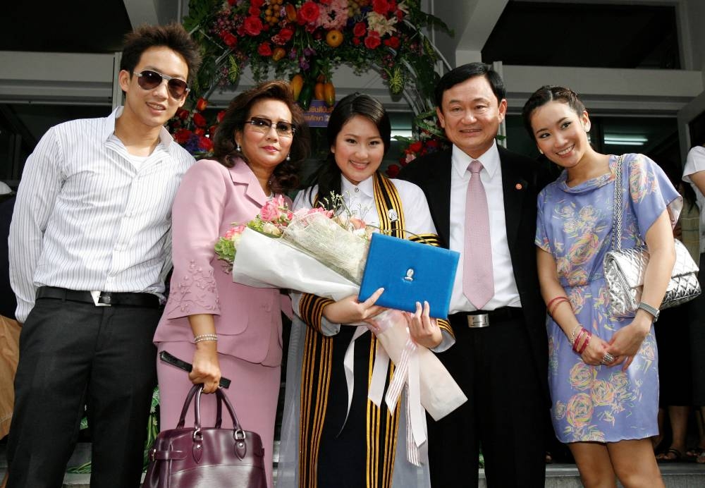 Ousted Thai Prime Minister Thaksin Shinawatra, who was deposed in a bloodless 2006 coup, poses for a family photo on the graduation day of his daughter Paetongtarn (centre) at a Bangkok university July 10, 2008. — Reuters file pic