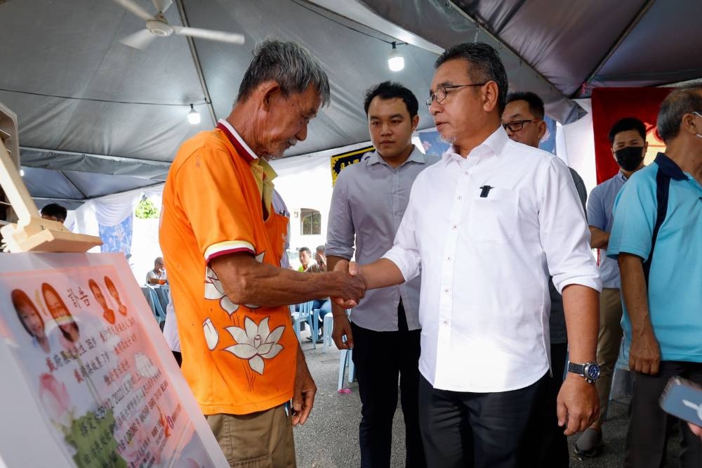 Deputy Defense Minister Adly Zahari (right) conveying his condolences to the relatives of Batang Kali landslide victims, Tai Seng Fui, 63, (left) while paying his last respects at his family's residence in Kampung Machap Baru, December 26, 2022. — Bernama pic
