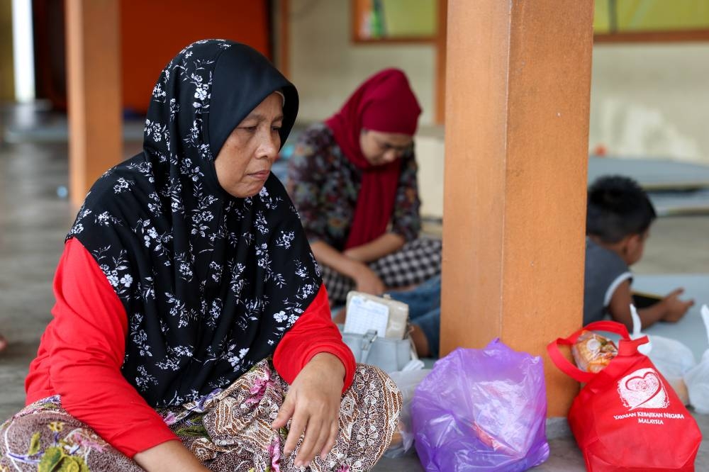 Single mother Aishah Salleh stares off into space at the temporary flood relief centre in Sekolah Kebangsaan (SK) Kedai Tanjong, Pasir Mas December 27, 2022. — Bernama pic