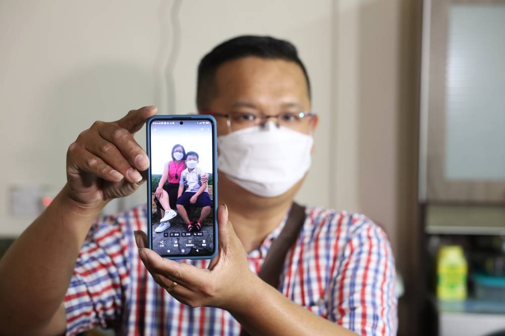 Medicine trader Tong Chee Kong shows a picture of his wife Lai Lee Koon, 44, and son Tong Kai En, nine, who were involved in the Batang Kali landslide when met by Bernama at his residence in Taman Dato’ Senu, Kuala Lumpur December 28, 2022. — Bernama pic