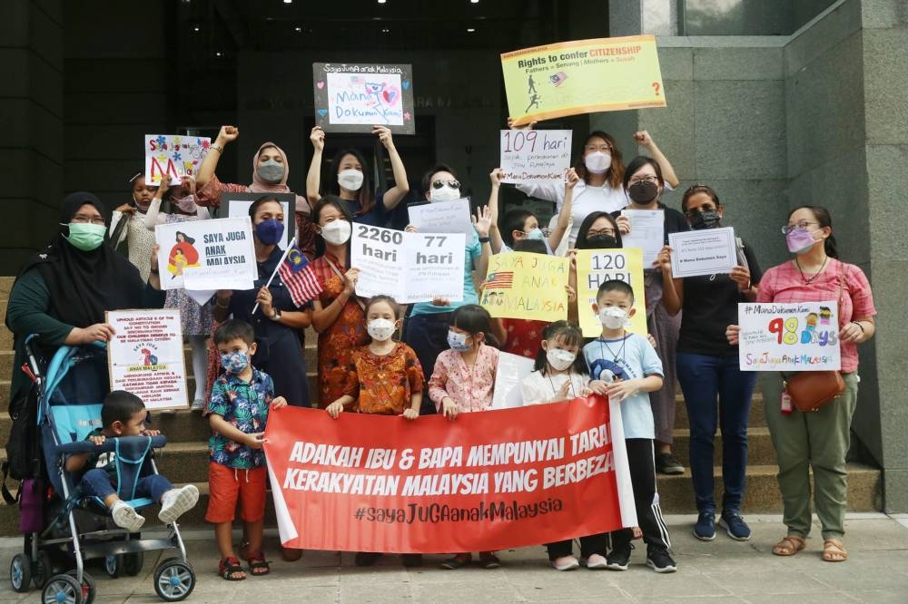 Malaysian mothers and their children pose with placards and banners during the follow-up of their overseas-born children’s Malaysian citizenship in JPN Putrajaya June 10, 2022. — Picture by Choo Choy May