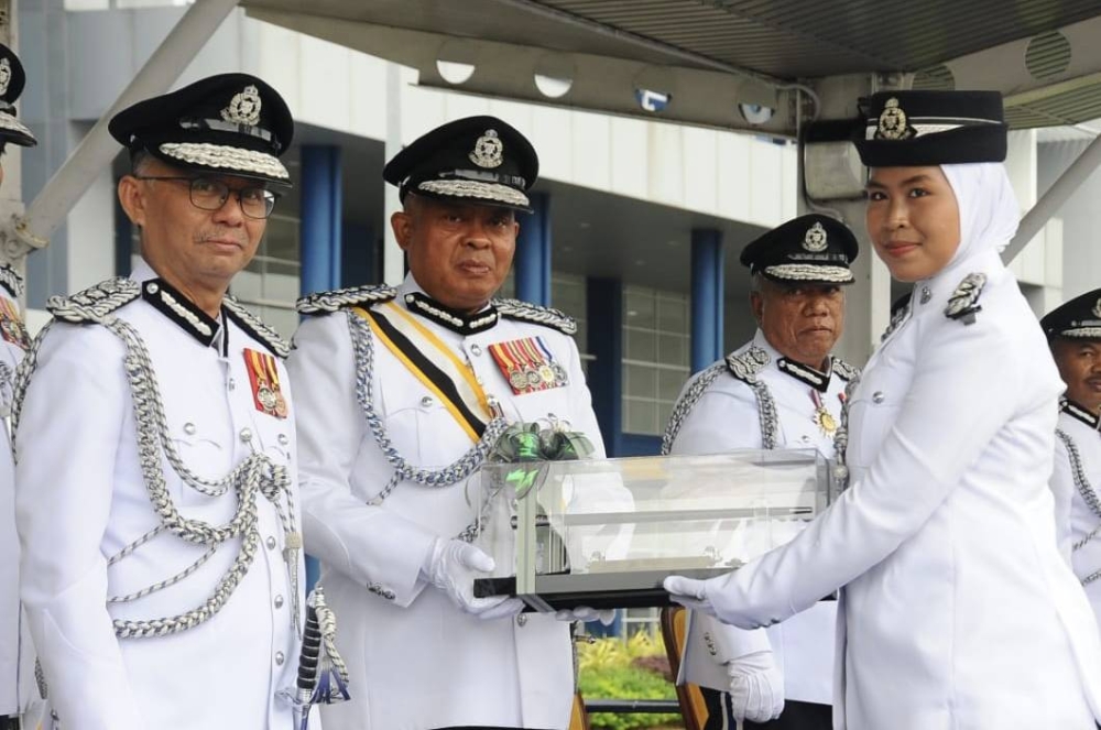 Johor police chief Datuk Kamarul Zaman Mamat (centre) presenting certificates to volunteer corps inspectors at the Johor police contingent headquarters in Johor Baru December 29, 2022. – Picture by Ben Tan