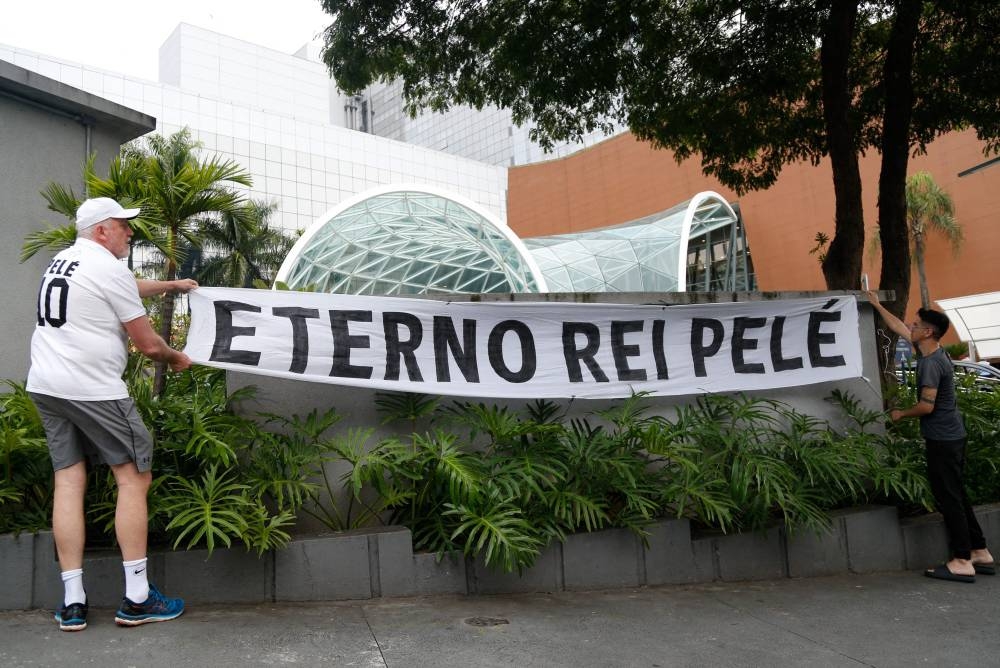Fans of Brazilian football legend Pele hang a banner reading 