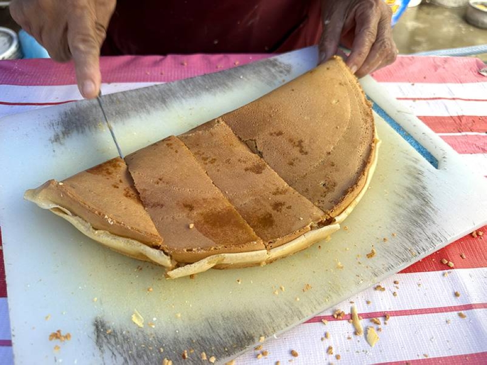 The 'apam balik' is quickly cut into pieces to make it easier to enjoy.