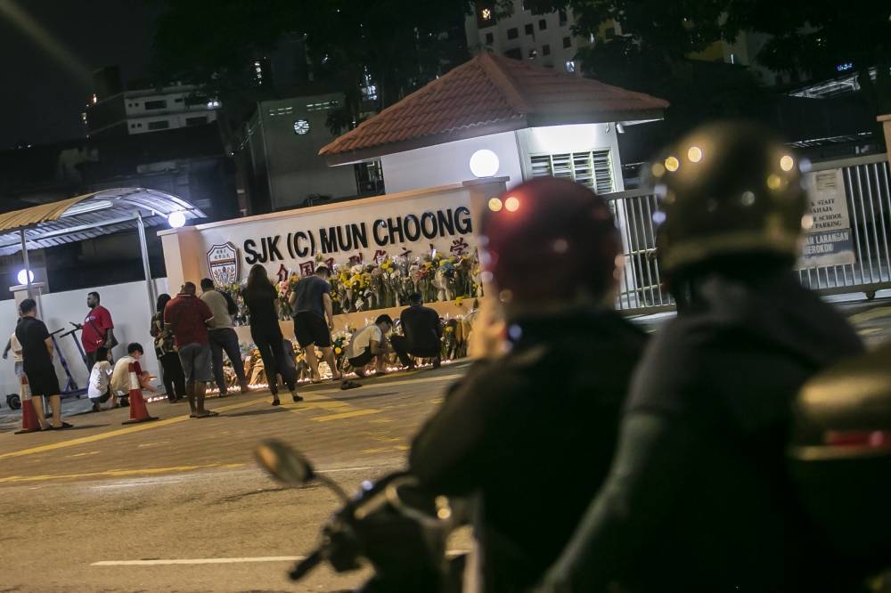 People take part in a candlelight vigil at the main entrance of SJKC Mun Choong on Jalan Ipoh December 18, 2022. — Picture by Hari Anggara         