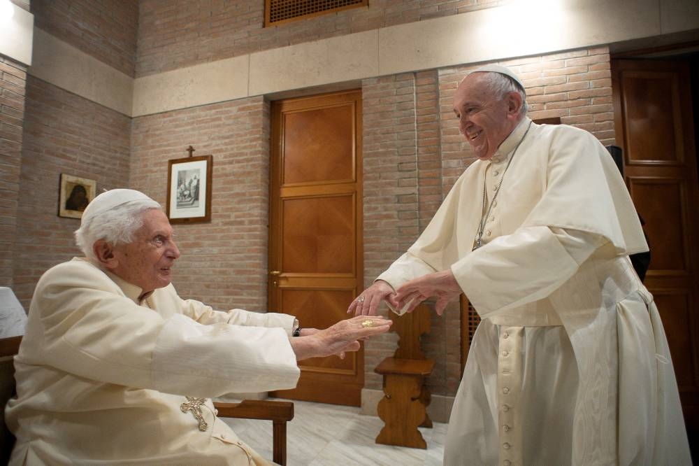 Pope Francis greets Pope Emeritus Benedict XVI during a meeting following a consistory ceremony to install 13 new cardinals, at the Vatican, November 28, 2020. — Reuters pic