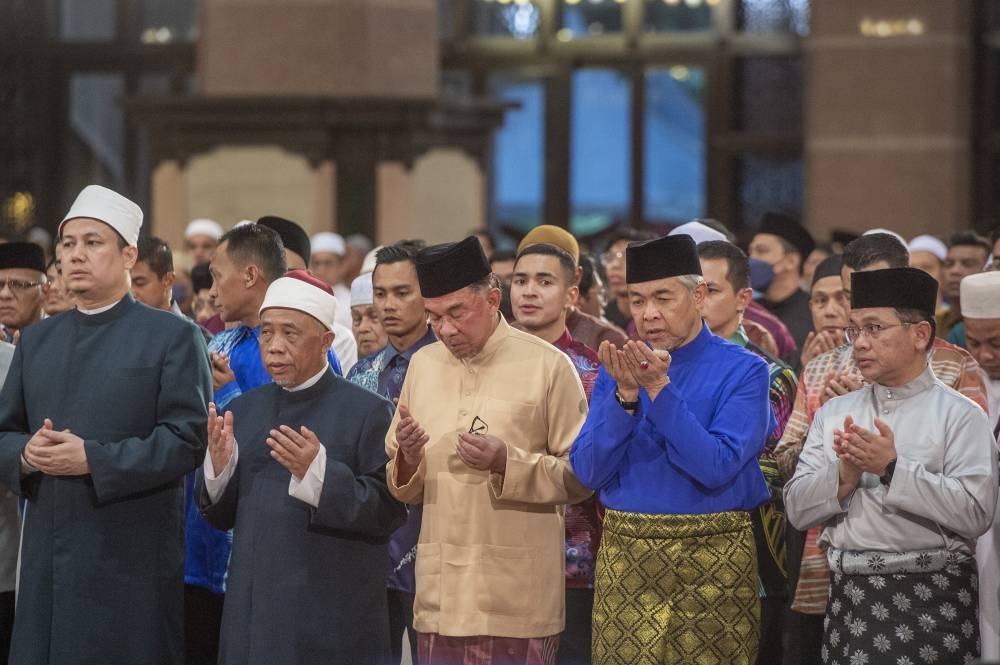 Prime minister, Datuk Seri Anwar Ibrahim  (centre) performs congregational prayer at a low-key New Year’s Eve event at the majestic Putra Mosque in Putrajaya where thousands of Muslims gathered to usher in 2023 —  Picture by Shafwan Zaidon