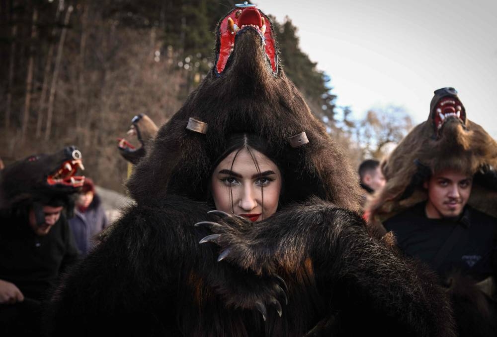 A reveller wearing a bearskin costume poses during the Bearskin Parade in Comanesti, Romania, on December 30, 2022. — AFP pic