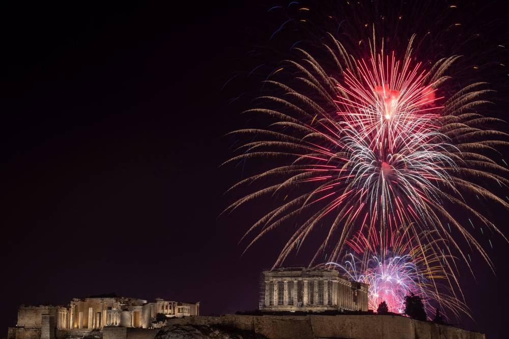 Fireworks explode over the ancient Parthenon temple atop the Acropolis hill during New Year's Day celebrations, in Athens, Greece, January 1, 2023. — Reuters pic