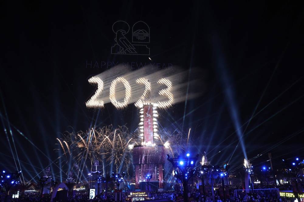 People attend a light and drone show to celebrate the New Year in Al Wathba, near Abu Dhabi on December 31, 2022, during the Sheikh Zayed Festival. — AFP pic