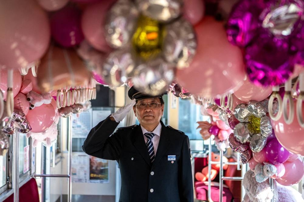 In this picture taken on October 20, 2022, Katsunori Takemoto, president of the Choshi Electric Railway, poses for a photo on a train at the company's Nakanocho station in Choshi, northeast Chiba prefecture. — AFP pic