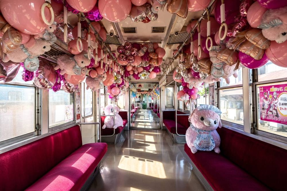 2022年10月20日に撮影されたこの写真は、千葉県北東部の草師市の中野町駅で、酢漬け会社の象徴的なアルパカのぬいぐるみで飾られた草子電鉄線の電車の車内を示しています.  - AFP画像