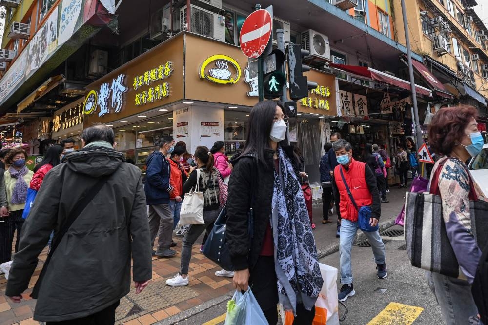 People walk along a street in the town of Sheung Shui near the border of mainland China in Hong Kong on January 4, 2023 ahead of the opening of the border on January 8. — AFP pic