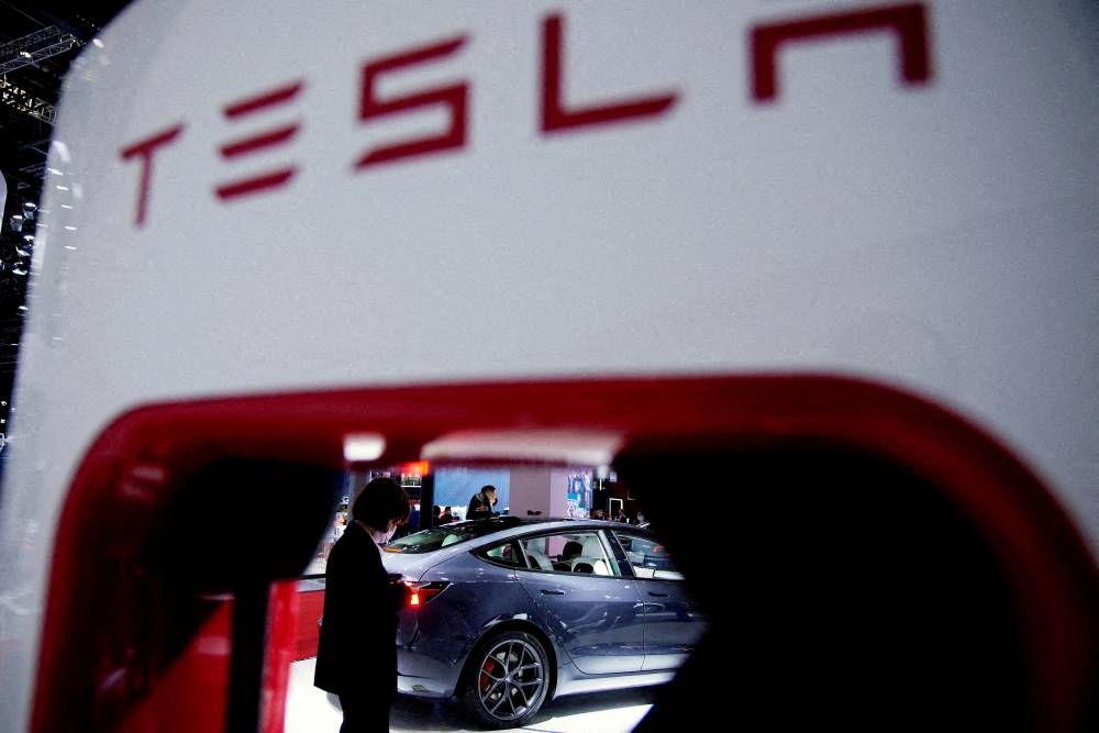 Tesla electric vehicle is seen through a charging point displayed during a media day for the Auto Shanghai show in Shanghai April 20, 2021. — Reuters pic