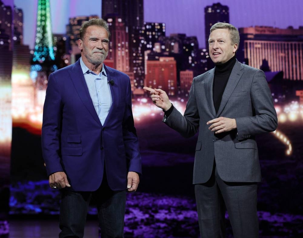 (From left) Actor Arnold Schwarzenegger  appears onstage with Chairman of the Board of Management of BMW AG Oliver Zipse during the BMW keynote address at CES 2023 at The Pearl concert theater at Palms Casino Resort on January 4, 2023 in Las Vegas, Nevada. — Ethan Miller/Getty Images via AFP pic