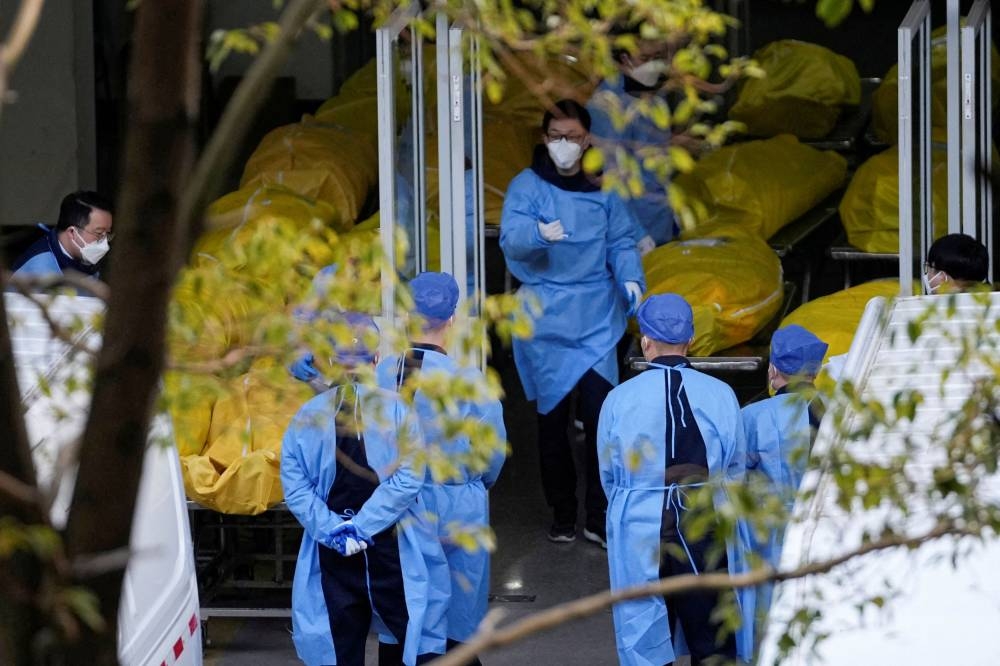 A staff member walks next to bodies in body bags at a funeral home, as Covid-19 outbreaks continue in Shanghai, China, January 4, 2023. — Reuters pic