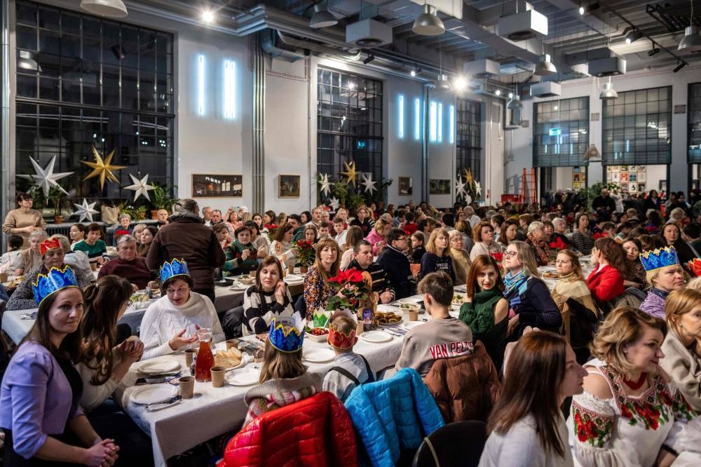 Participants attend the Christmas supper for Ukraininan refugees staying in Warsaw on Orthodox Christmas Eve in Warsaw, Poland on January 6, 2023. — AFP pic