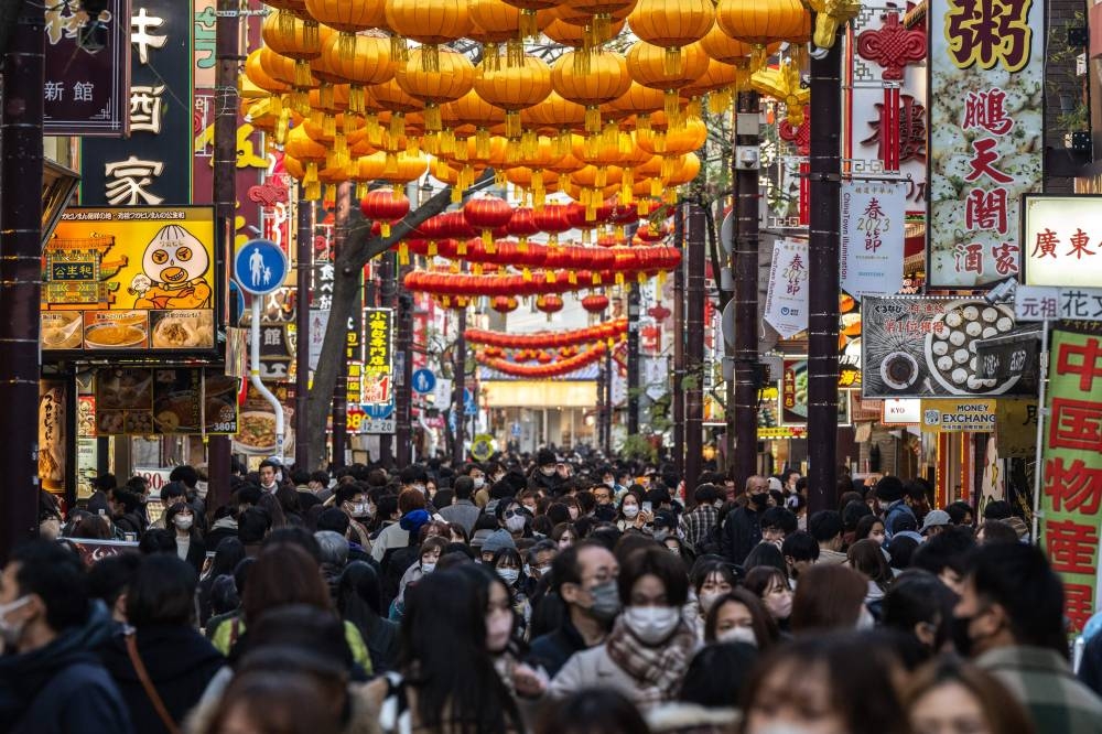 People walk down a street in the Chinatown section of Yokohama, Kanagawa prefecture, south of Tokyo, on January 7, 2023. — AFP pic