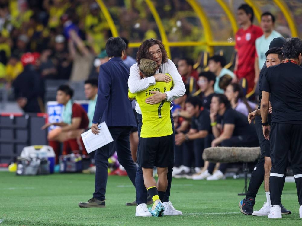 Harimau Malaya head coach Kim Pan Gon hugs Mohamad Faisal Abdul Halim after his winning goal against Thailand. — Bernama pic