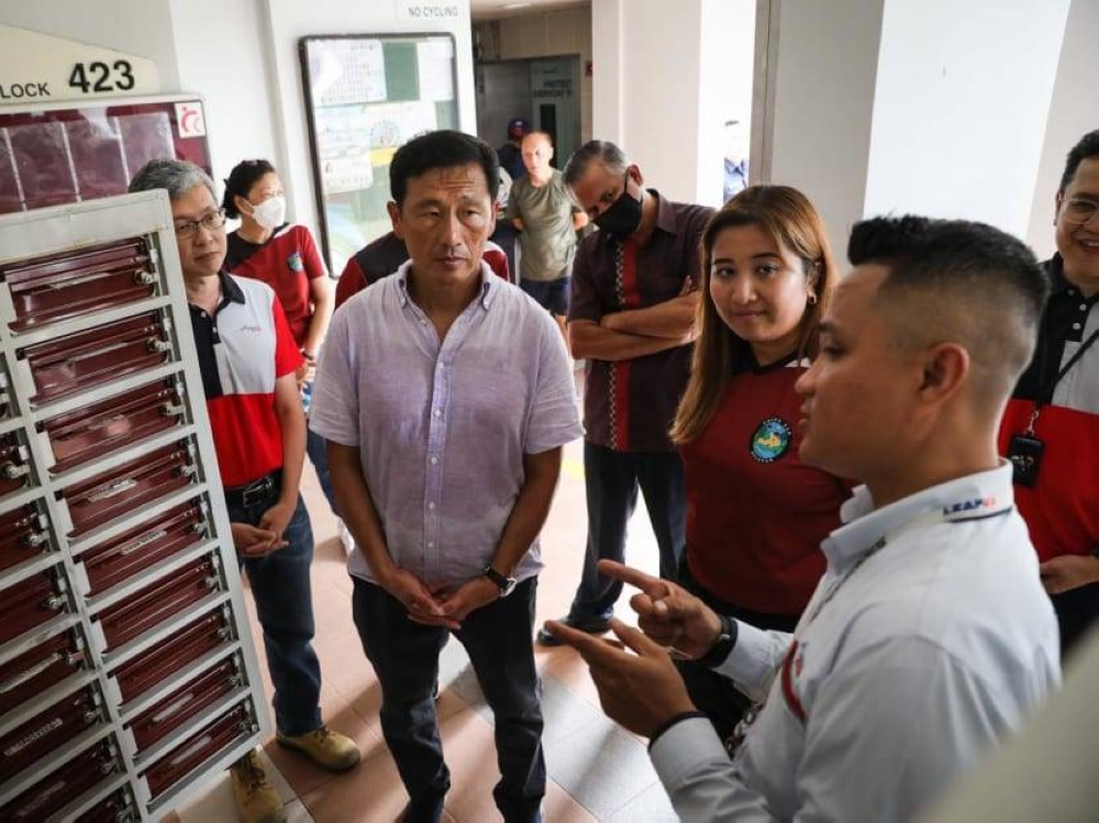 Ms Nadia Ahmad Samdin, MP for Ang Mo Kio GRC, and Minister for Health Ong Ye Kung speak to a SingPost postman who is trained to monitor letterboxes for irregularities in mail collection patterns of the residents in Cheng San precinct on Jan 8, 2023. — TODAY pic