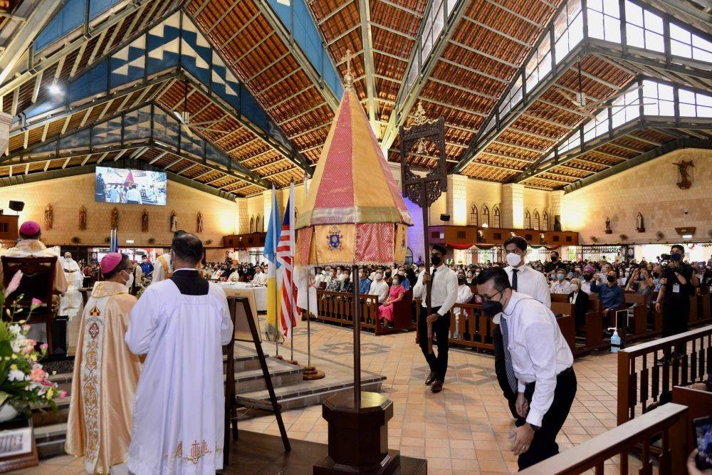 In the solemn declaration ceremony, the two papal symbols, the 'ombrellino' (little umbrella) and a silk canopy with yellow and red liveries were carried inside to be displayed. — Picture by Opalyn Mok