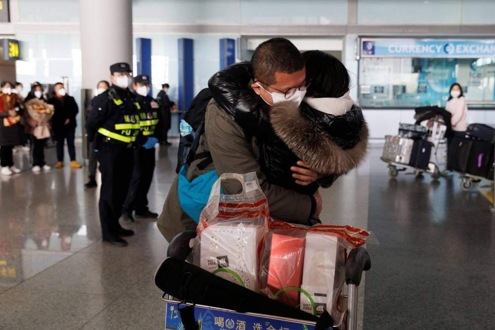 People embrace at the international arrivals gate at Beijing Capital International Airport after China lifted the Covid-19 quarantine requirement for inbound travellers in Beijing, China January 8, 2023. ― Reuters pic