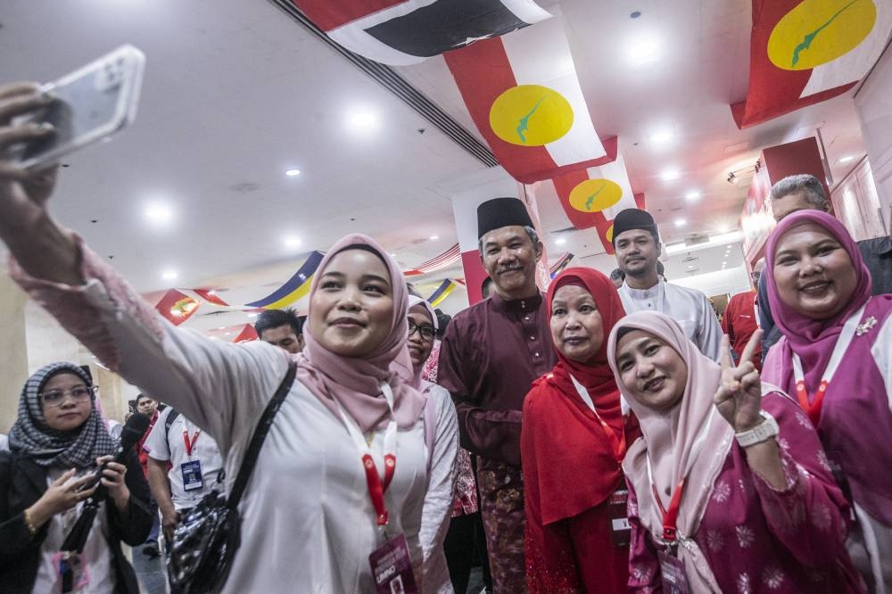 Datuk Seri Mohamad Hasan pose for photos with Umno members at World Trade Centre Kuala Lumpur January 11, 2023. — Picture by Hari Anggara