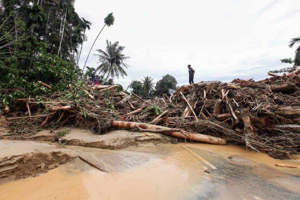 Workers pictured clearing the aftermath of the flash floods that took place in Kampung Bukit Iboi, Baling, Kedah July 5, 2022. — Picture by Sayuti Zainudin