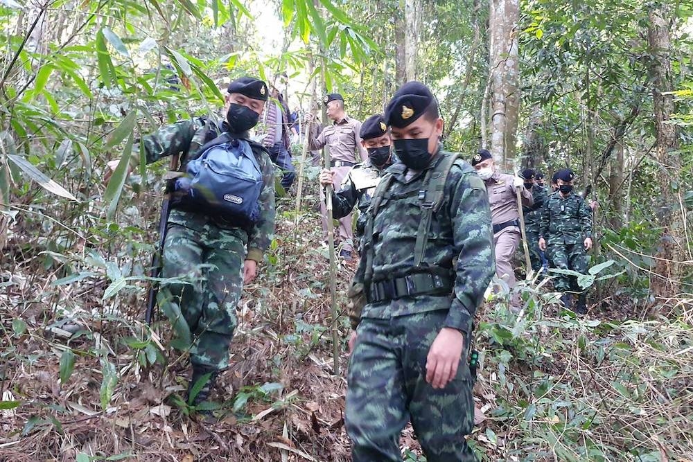 This handout photo taken and released on January 12, 2023 by the Royal Thai Army's Pha Muang Task Force shows members of the Pha Muang Task Force and Thai security personnel walking through a forested area of Chiang Rai province in northern Thailand, following a clash with suspected drug traffickers. — Handout / Pha Muang Task Force / AFP