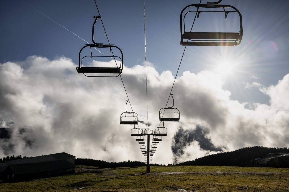 This photograph taken on December 27, 2022 shows a stopped chairlift at Le Semnoz ski resort, near Annecy, as the resort had to close temporarily due to the lack of snow.— AFP pic