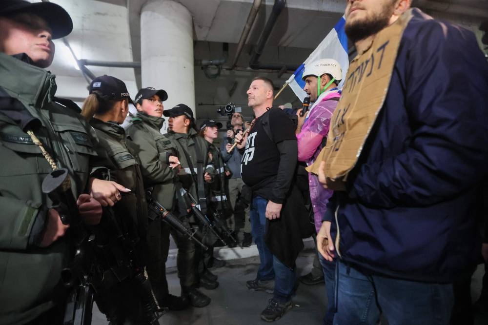 Israeli security forces and left wing protesters face-off during a rally against Prime Minister Benjamin Netanyahu's new hard-right government in the coastal city of Tel Aviv on January 14, 2023. — AFP pic