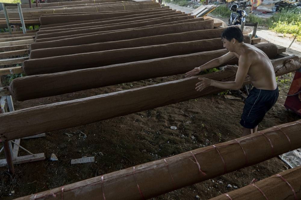 A worker working on a 16-ft joss stick. — Picture by Shafwan Zaidon