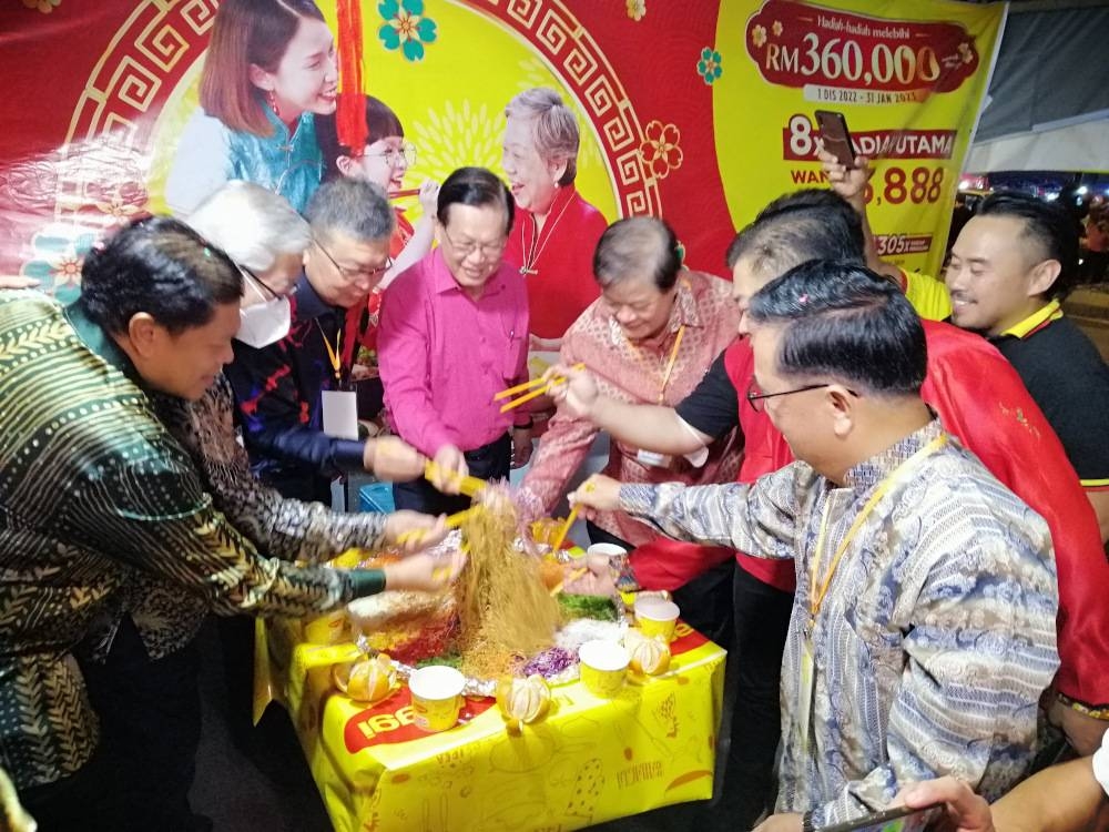 Datuk Seri Lee Kim Shin.(centre) joins MCCI members and guests for the yee sang toss. Abdul Aziz is at left. — Borneo Post pic