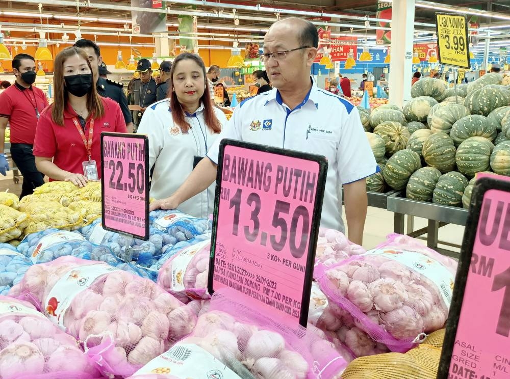 Melaka Unity, Information, Human Resources and Consumer Affairs Committee chairman Ngwe Hee Sem (right) checks prices of goods after the launch of the Festive Season Maximum Price Scheme (SHMMP) in Melaka January 16, 2023. — Bernama pic