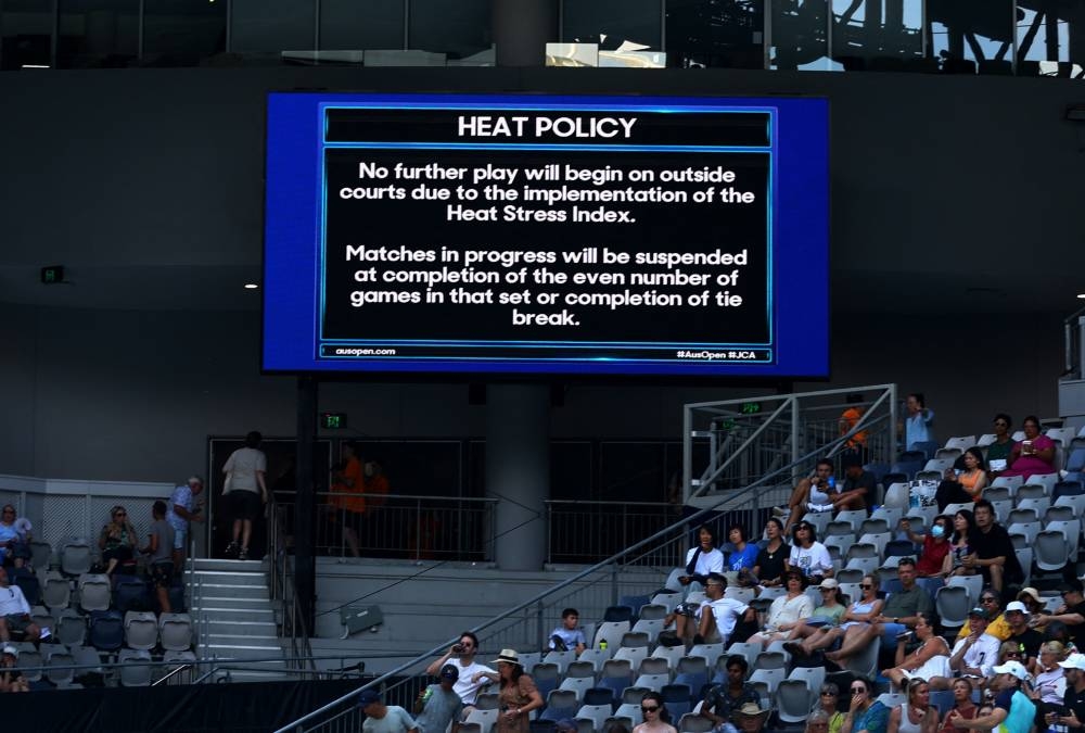 Heat policy message is displayed on the big screen as play is suspended on the outside courts due to high temperatures, January 17, 2023. — Reuters pic