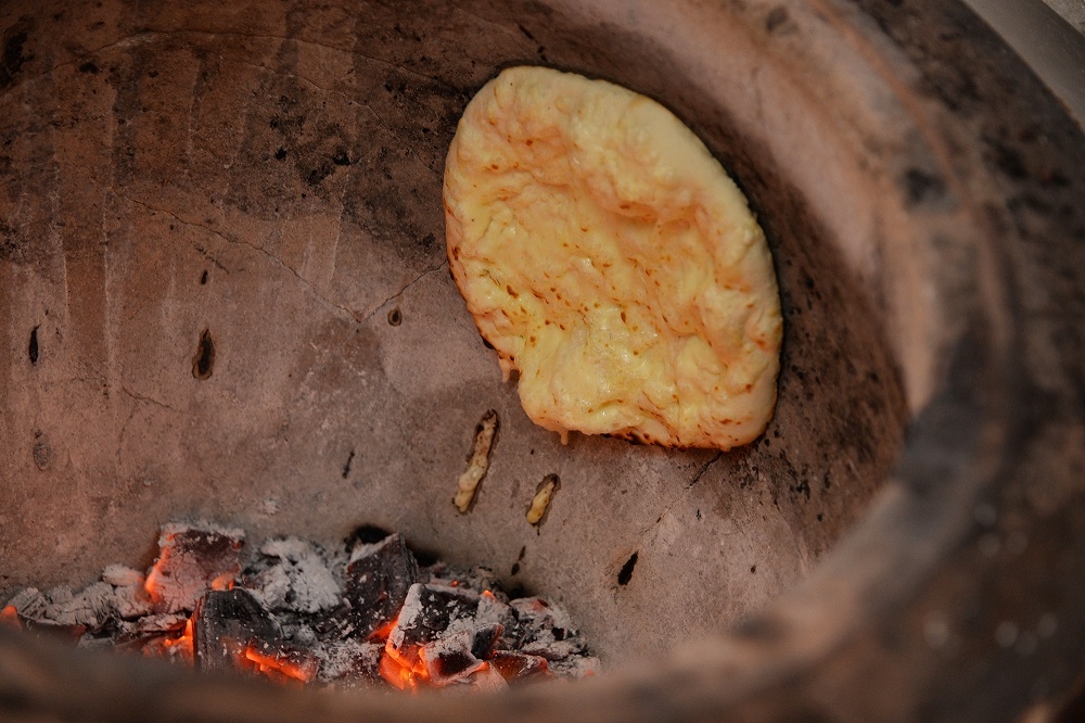 Cheese naan baking in the charcoal tandoori oven.