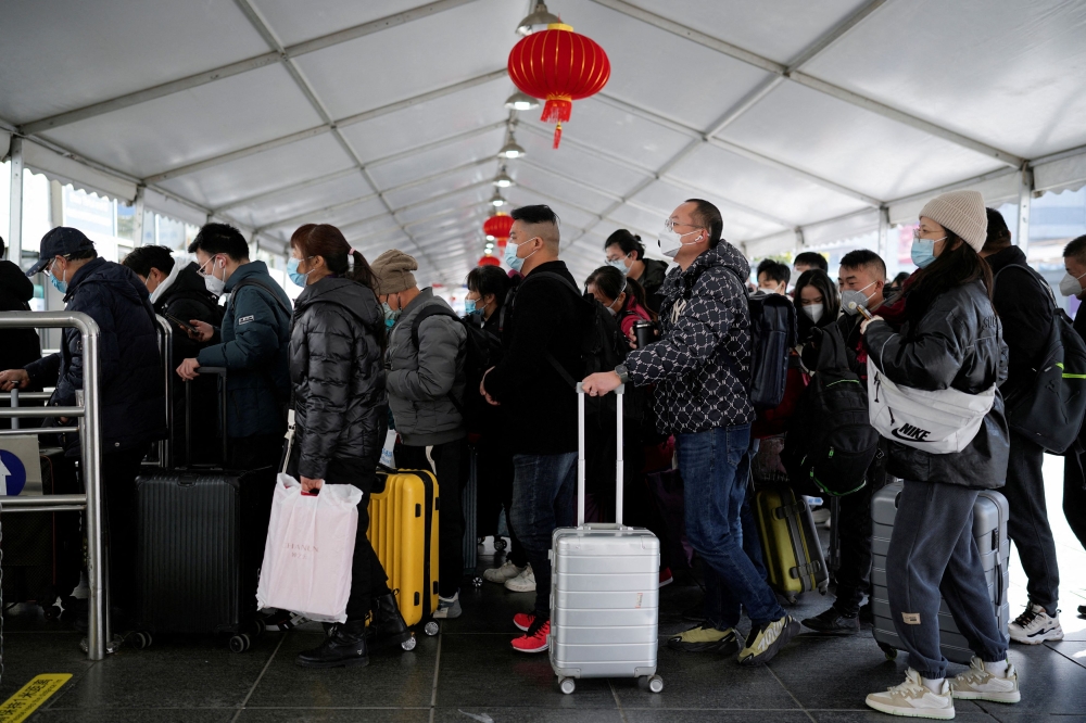 People walk with their luggage at a railway station during the annual Spring Festival travel rush ahead of the Chinese Lunar New Year, as the coronavirus disease (COVID-19) outbreak continues, in Shanghai January 16, 2023. — Reuters pic