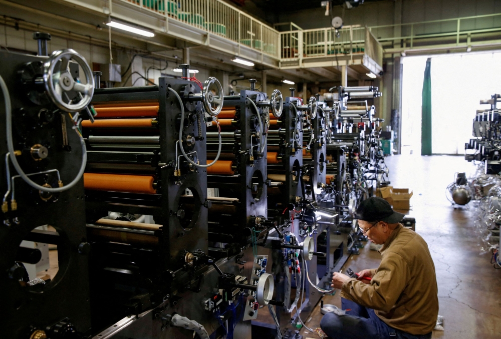 A worker checks machinery at a factory in Higashiosaka, Japan June 23, 2022. — Reuters pic