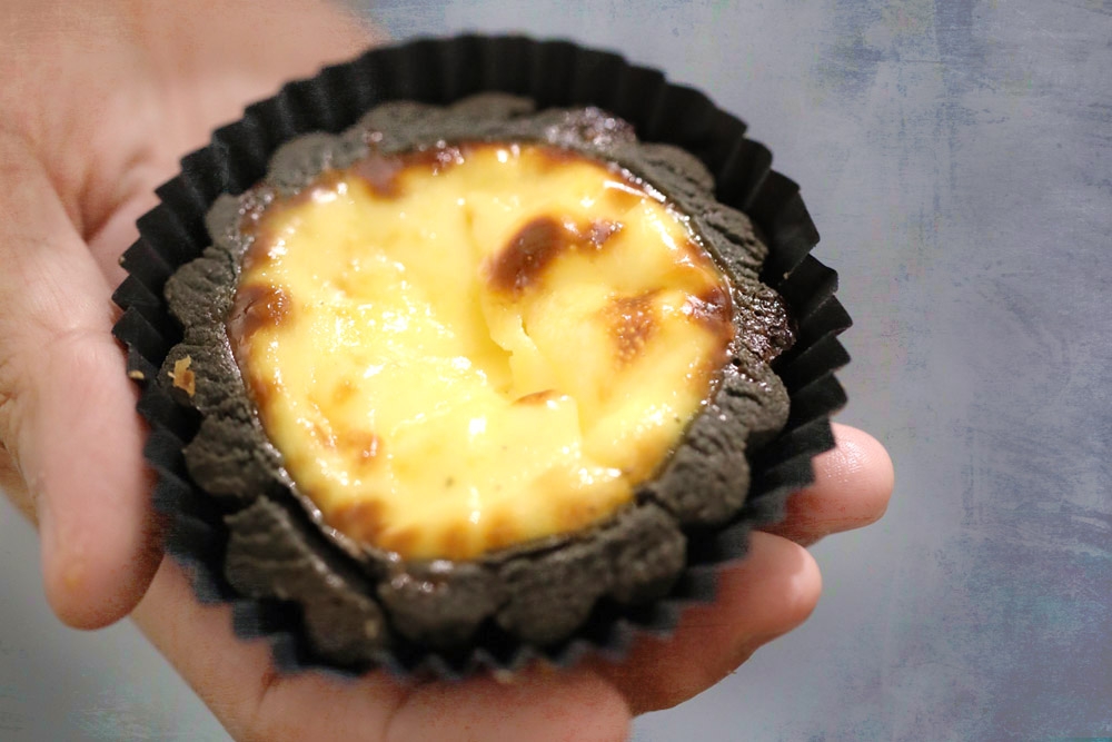 The charcoal egg tart at Noon Viennoiserie has a hidden heart of sticky, chewy 'mochi.' — Pictures courtesy of CK Lim