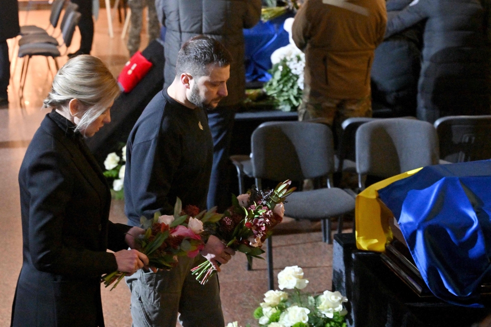 Ukrainian President Volodymyr Zelensky and his wife Olena attend the funeral ceremony of Ukrainian Interior Minister Denys Monastyrsky and other employees of his department at the Ukrainian House in Kyiv on January 21, 2023. ― AFP pic