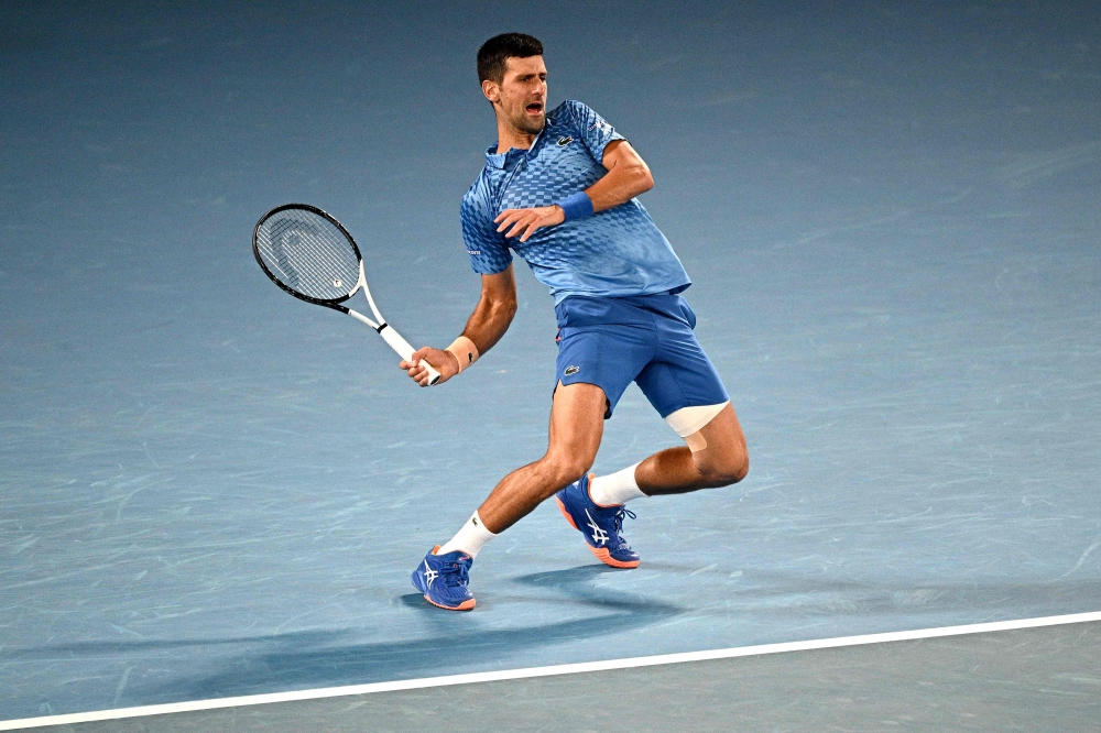 Serbia’s Novak Djokovic hits a return against Bulgaria’s Grigor Dimitrov during their men's singles match on day six of the Australian Open tennis tournament in Melbourne on January 21, 2023. ― AFP pic